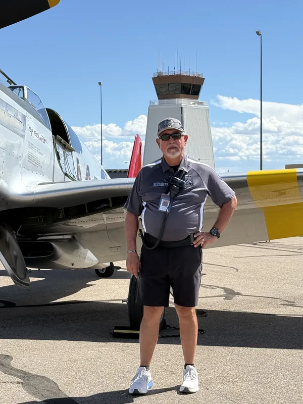 Paul Martinez on duty at the Pueblo Airshow next to a P-51 Mustang