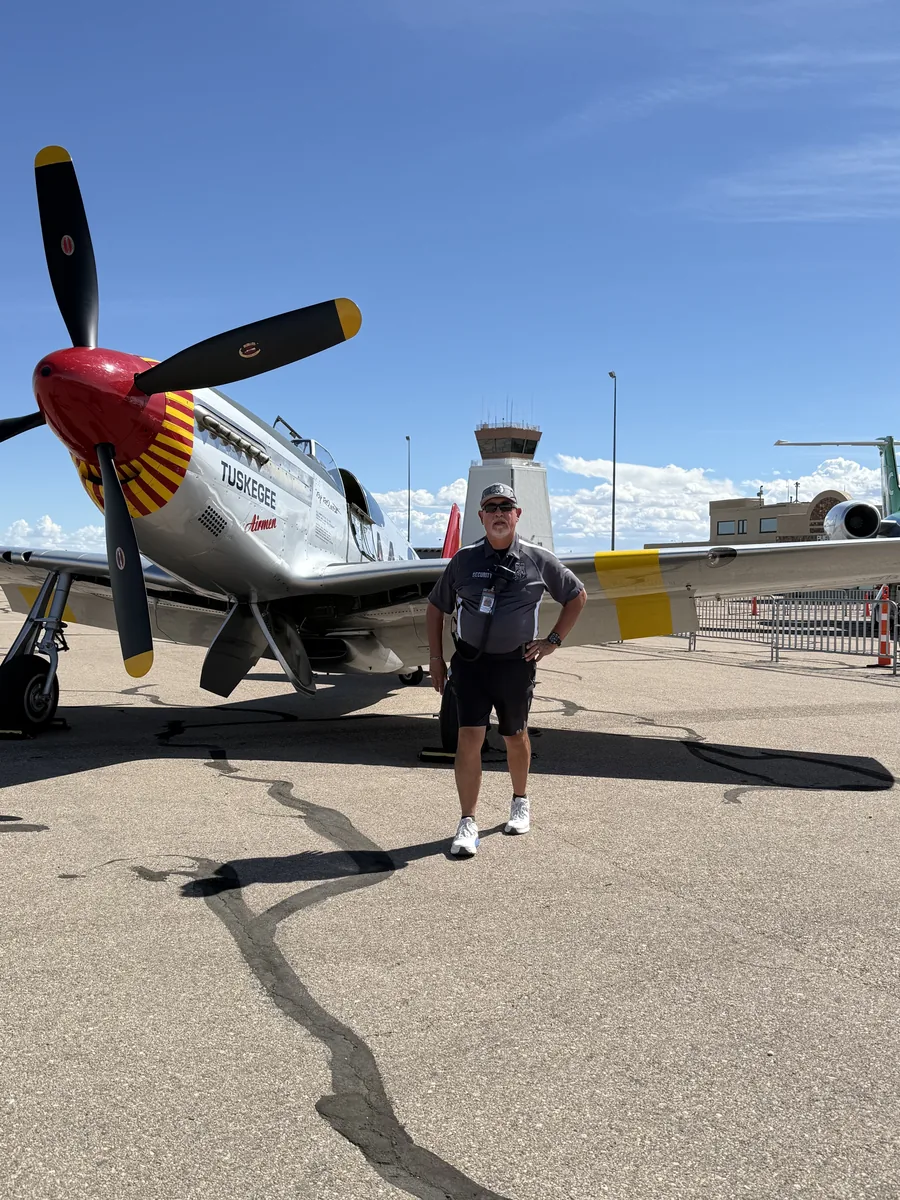 Paul Martinez on duty at the Pueblo Airshow with a P-51 Mustang in the background